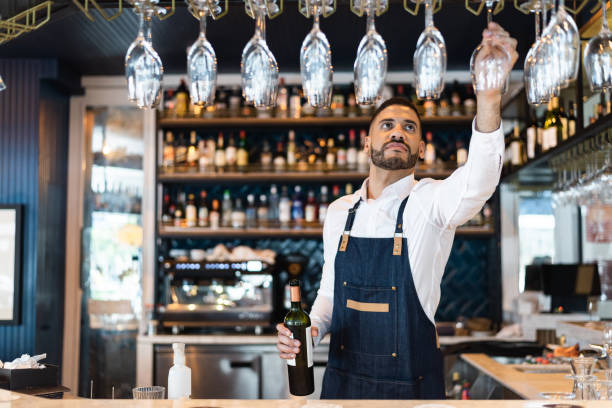 istock Bartender picking up a glass of wine 1276803848