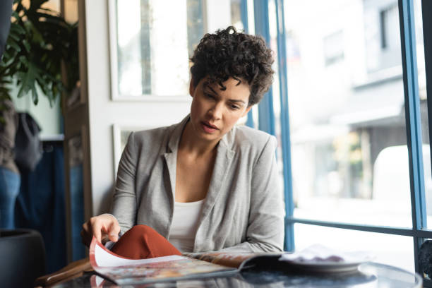 Woman leafing through a magazine in the restaurant