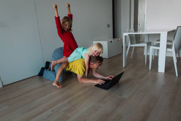 istock family stay home, father work on computer while kids climbing on him 1276804818