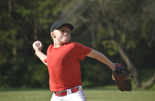 waist up view of 9 year old baseball pitcher about to release ball, summer\nNaperville, Illinois  USA