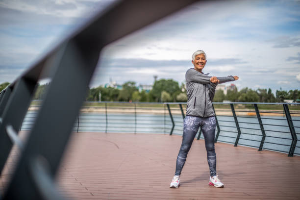 istock Active senior woman warming up by the river for jogging 1276810000