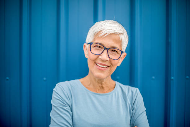 istock Happy senior woman against blue background. 1276810794