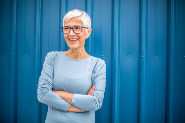 Happy senior woman against blue background.