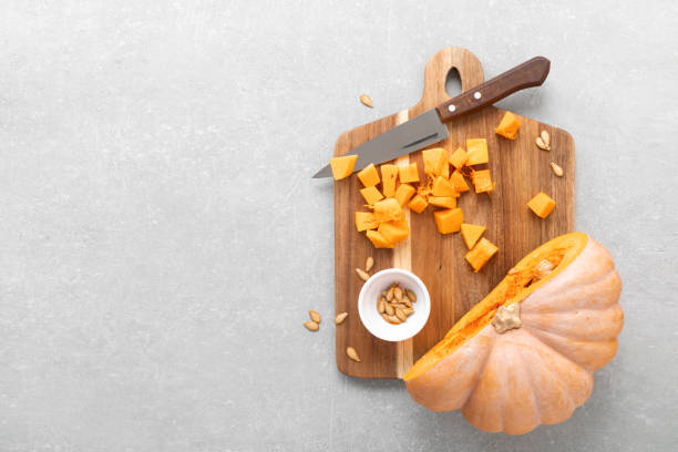 istock Fresh raw sliced butternut squash on wooden board, copy space for text, top down view 1276814395