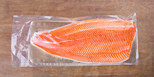 istock Vacuum packed salmon half fillet on wooden table 1276815794