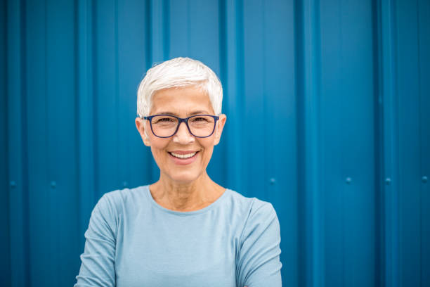 istock Happy senior woman against blue background. 1276816394