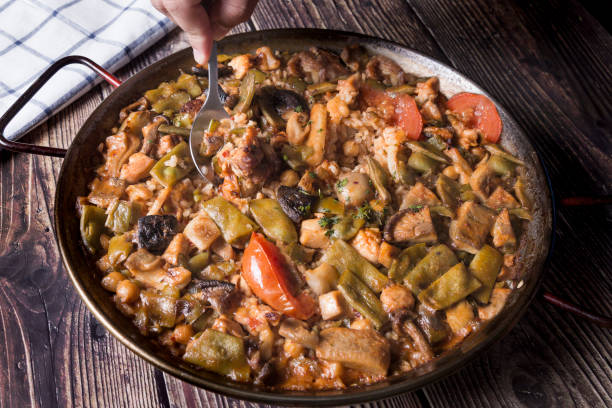 istock A man's hand, eating a vegetable paella with a spoon 1276816664