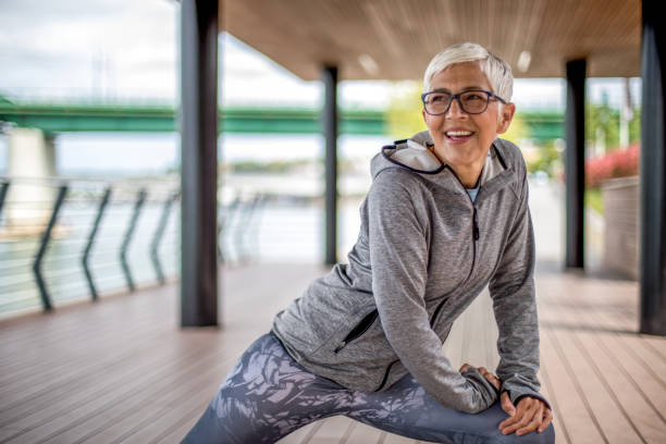 istock Active senior woman warming up by the river for jogging 1276817069