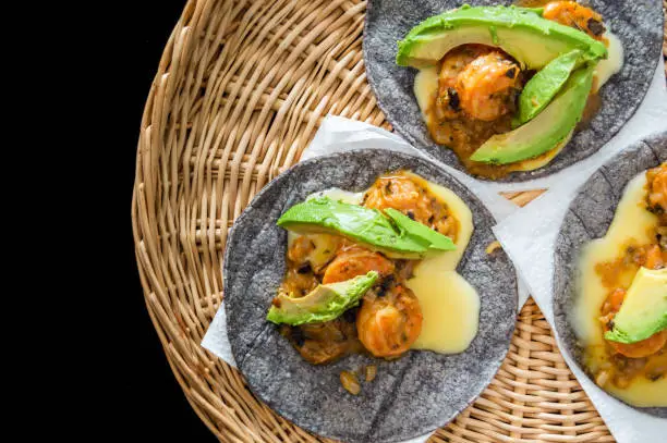 Tacos Gobernador (governors tacos), shrimp tacos cooked with spices and cheese, served on blue corn tortillas with avocado.