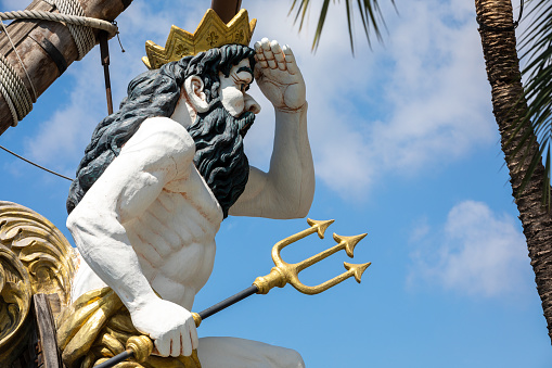 Observing with his hand on his forehead and the trident. He is the counterpart of the Greek god Poseidon.