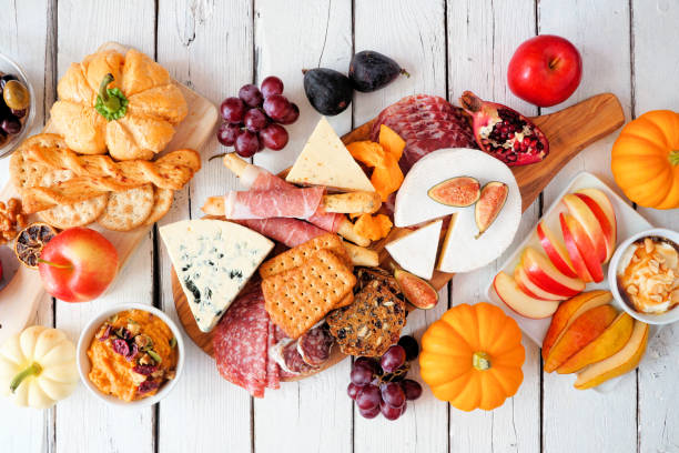 Autumn theme appetizer table scene against a white wood background