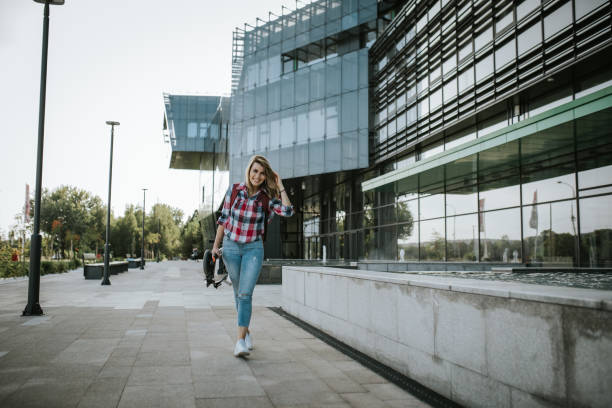 istock Female student walking to college carrying assembled push scooter 1276822055