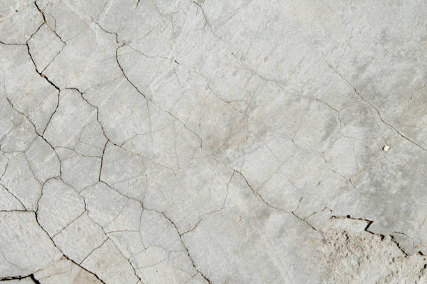 istock Cracked concrete texture. Faults and cracks on the stone surface. 1276823844