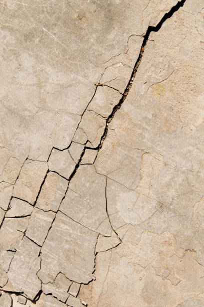 istock Cracked concrete texture. Faults and cracks on the stone surface. 1276824234