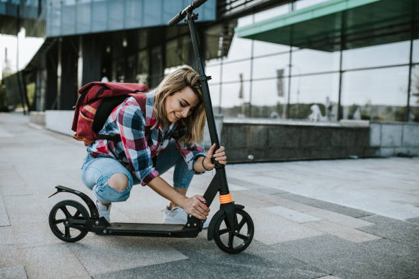 istock Female student is assembling her push scooter in front of college 1276825357