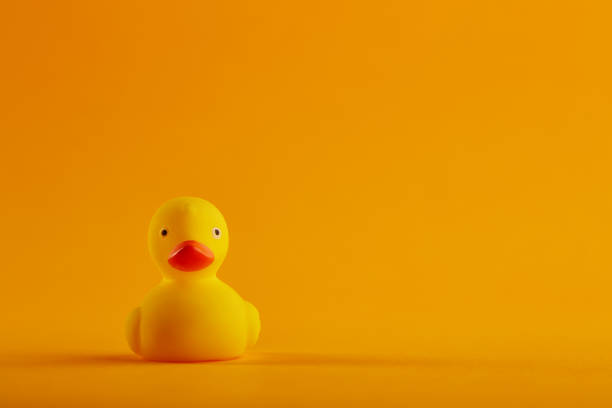istock Yellow rubber duck toy on orange / yellow background 1276833920