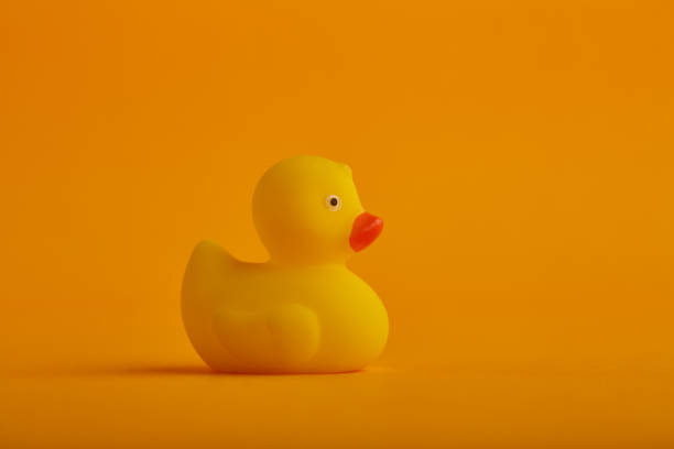 istock Yellow rubber duck toy on orange / yellow background 1276834009