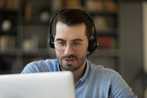 istock Male employee in headset talk consult client online 1276837790