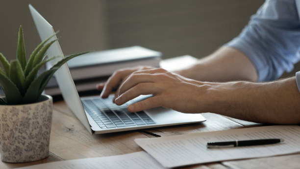 istock Close up of man tying on modern laptop keyboard 1276837793