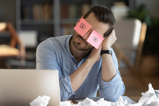 istock Tired male employee fall asleep at workplace 1276837803