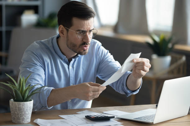 istock Unhappy young man frustrated by bill paying online 1276837813