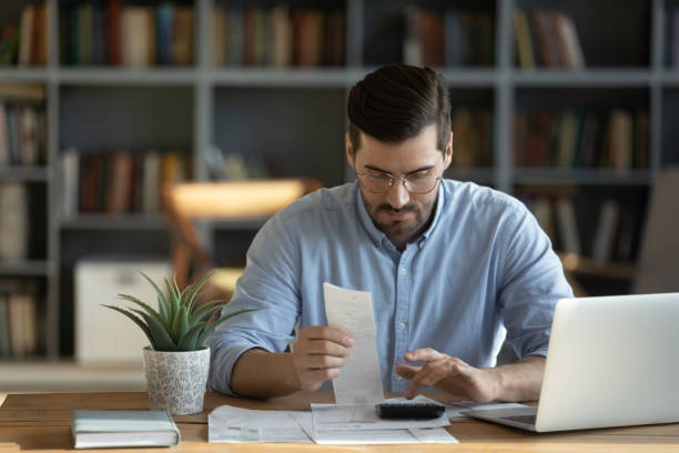istock Focused man calculate household finances at home 1276837817