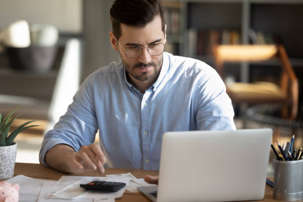 focuses hombre calcular gastos pagar facturas en línea - save costs fotografías e imágenes de stock