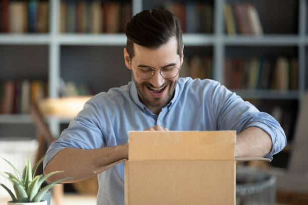 istock Happy male feel excited unpacking parcel with order 1276837825
