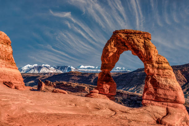 Delicate Clouds Clouds over Delicate Arch in Arches National Park delicate arch stock pictures, royalty-free photos & images