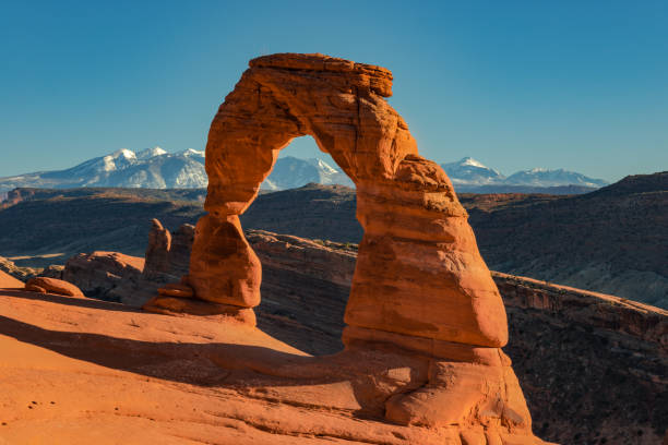 Delicate Mountains Delicate Arch in Arches National Park with mountains in the background natural bridges national park photos stock pictures, royalty-free photos & images