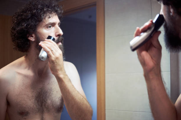istock Middle-aged Hispanic man cutting his beard 1276846386