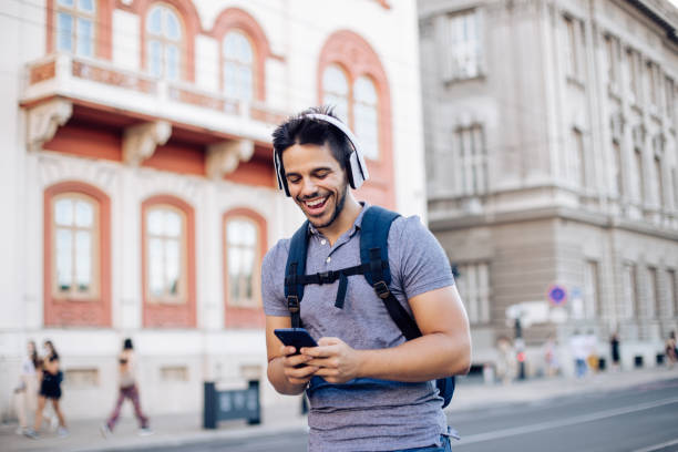 istock Happy student walking through the city and podcasting 1276861742
