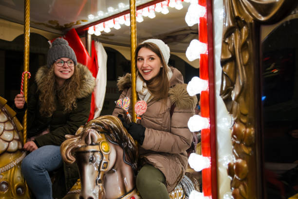 istock Two happy female friends riding on carousel 1276864577