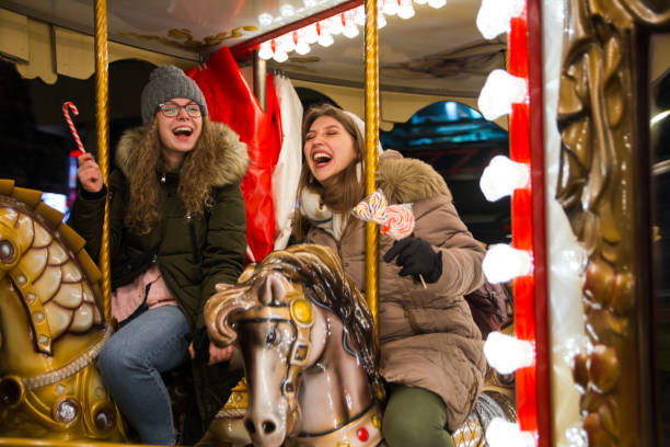 istock Two happy female friends riding on carousel 1276864667