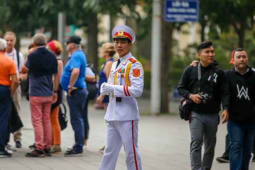 Hanoi, Vietnam - December 31, 2019: A ceremonial guard dressed in a crisp white uniform offering advice to tourists at the Ho Chi Minh Mausoleum on Hanoi Vietnam