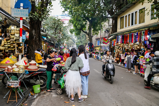 Hanoi, Vietnam - December 31, 2019: Vendors displaying their goods for sale on the busy sidewalks and streets of the French Quarter in Hanoi Vietnam.