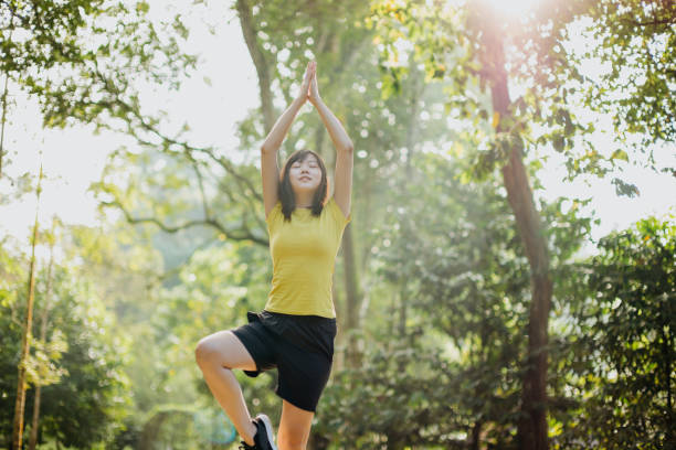 istock Young asian woman practicing yoga at the park 1276866229