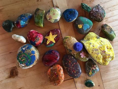 Children’s hand painted rocks for the Painted Rocks movement. Children paint rocks and hide them for other children to keep or reside.