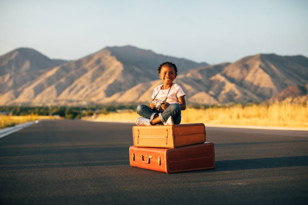Ready for holidays. A child inside a suitcase with a hat an sunglasses.
