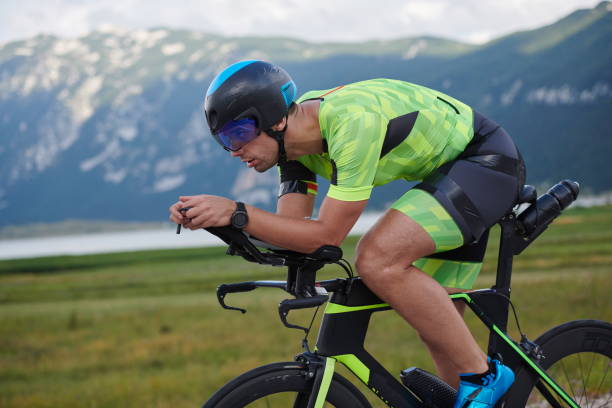 atleta de triatlón montando en bicicleta - triathlete fotografías e imágenes de stock