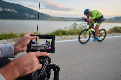 cinematographer taking action shot of triathlon bike athlete