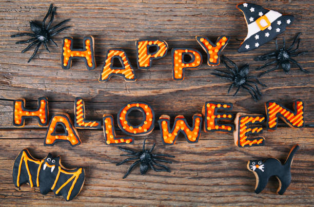 istock Happy Halloween with gingerbread handmade cookies on rustic wooden table 1276875454