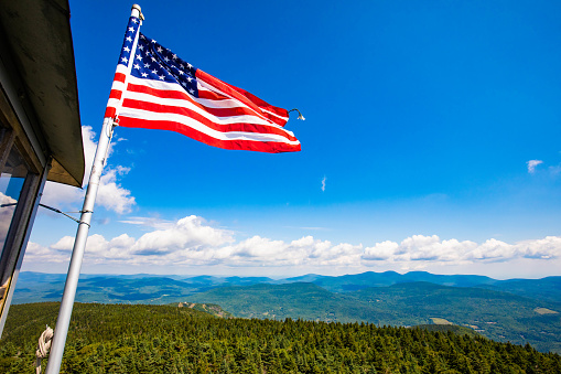 USA flag on top of the National Park mountain symbol of freedom summer day