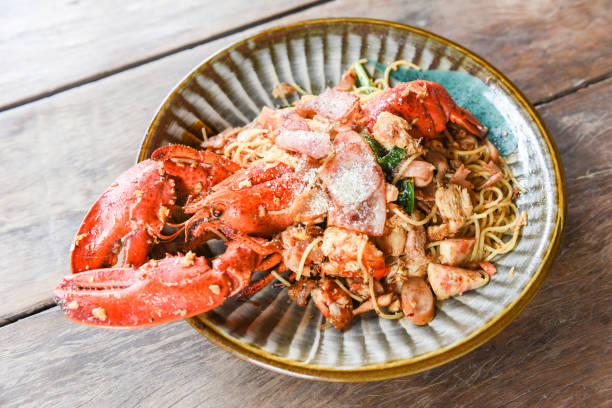 istock Grilled Lobster sausage ham vegetables and cheese spaghetti seafood on wooden table - Shellfish seafood plate with lobster dinner food cooked 1276880805
