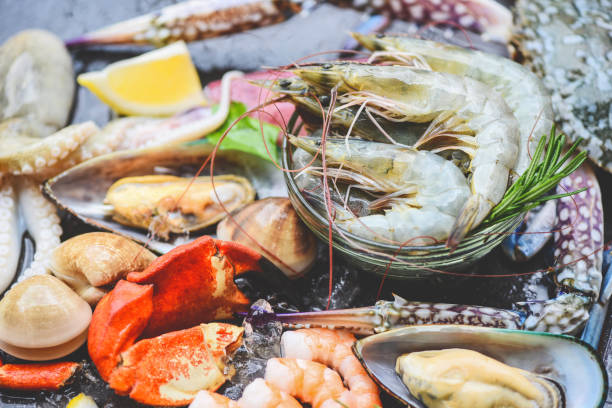 istock Seafood shellfish on ice frozen with shrimps prawns crab claws shell clam squids octopus and mussels at the restaurant Fresh raw seafood buffet with lemon rosemary ingredients herb and spices 1276880810