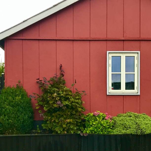 istock Small house with red wood paneling and little white window 1276887234