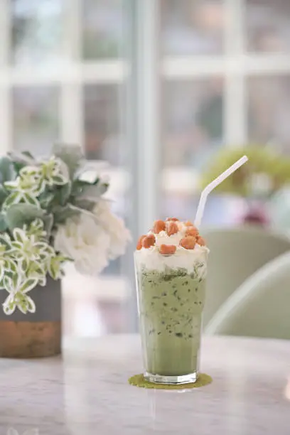 Green tea. Iced Japanese matcha greentea with whipped cream, caramel topping and maccademia nuts.