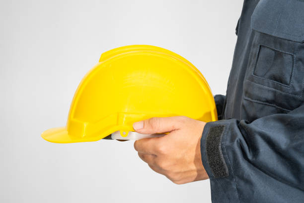 istock Close up Worker standing in blue coverall holding hardhat 1276888410