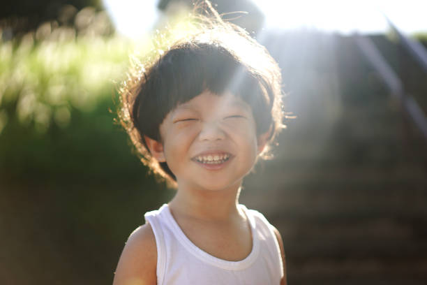 Portrait of smiling girl. Cute cheerful female kid is standing in yard. She is spending leisure time during sunny day.