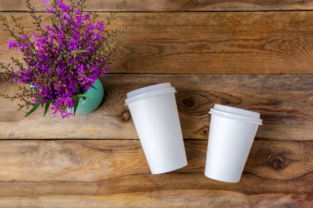 istock Paper coffee cup mockup with purple wildflowers 1276892159